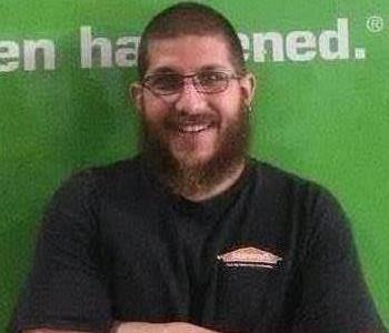 SERVPRO Employee Corey in front of a green work vehicle.